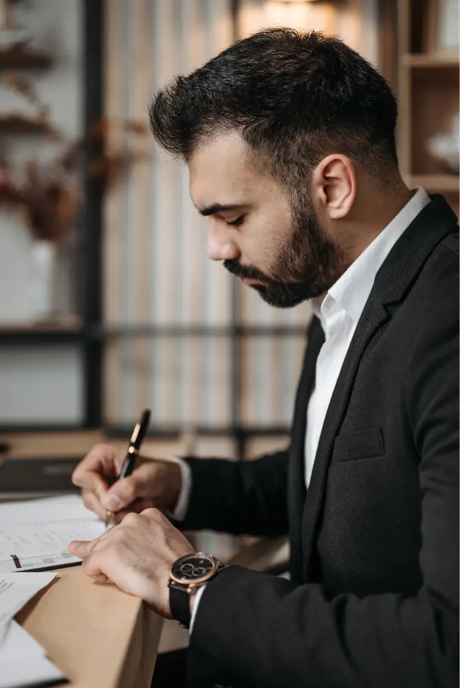 Lawyer, Man, Profile view, sitting at a desk writing.